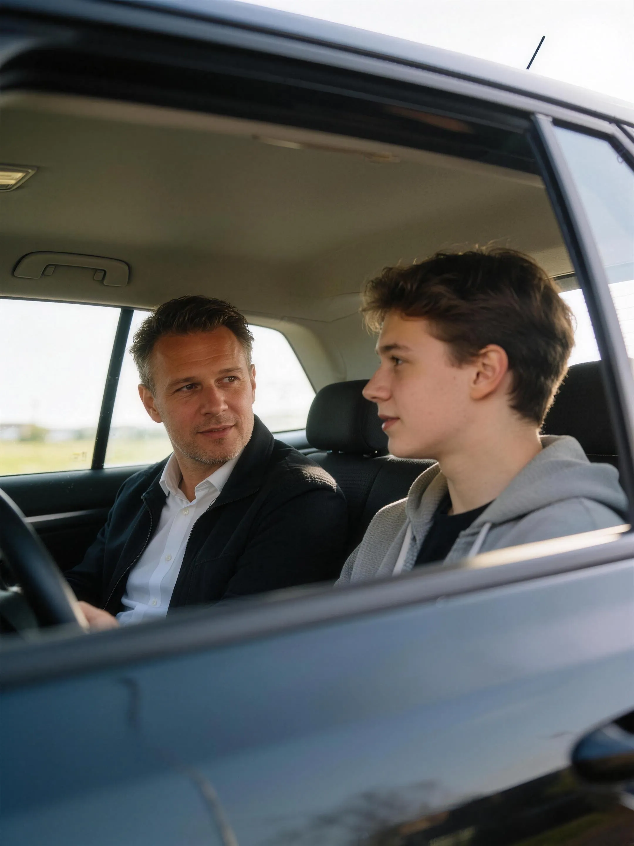 Instructeur en leerling in gesprek in de geparkeerde lesauto